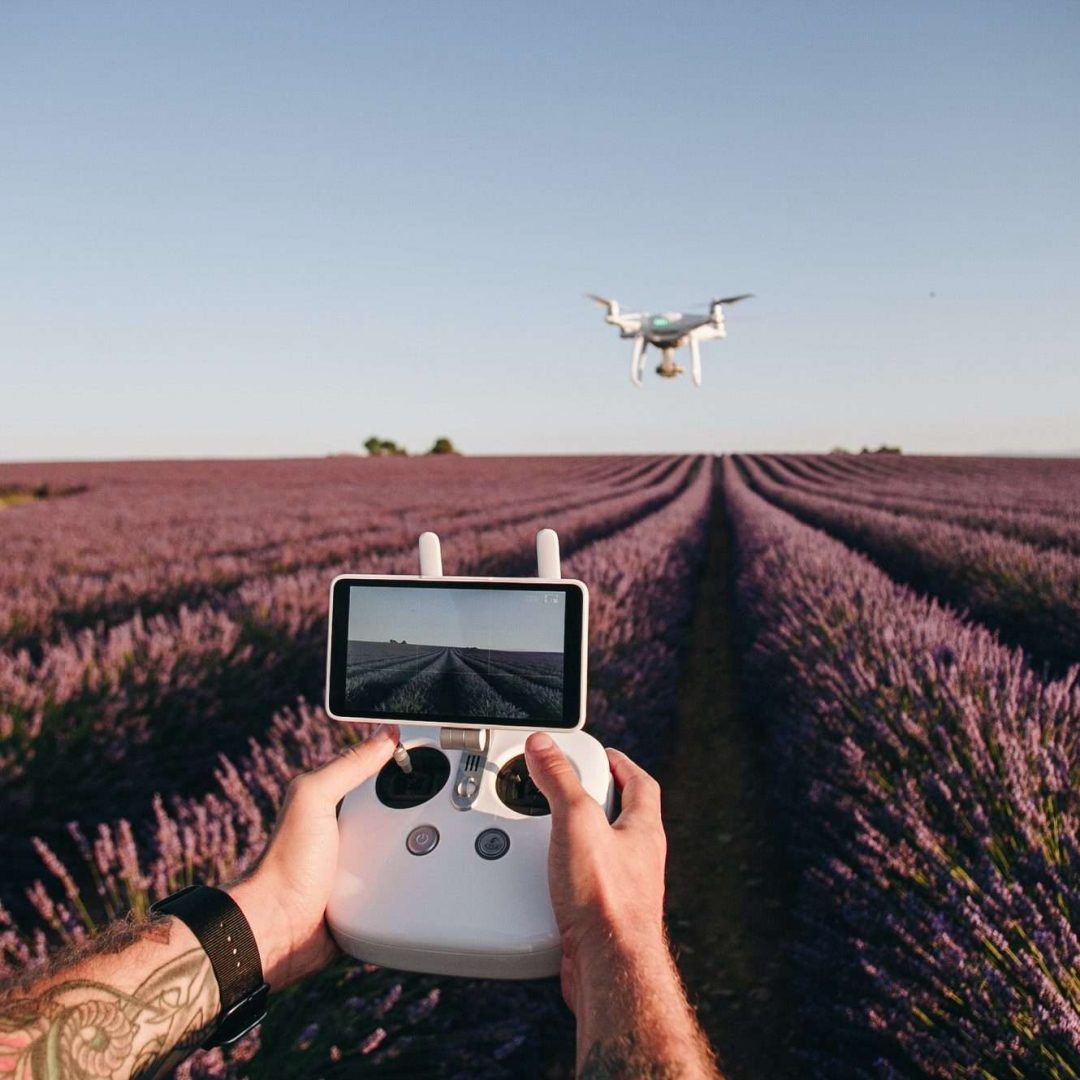 man-control-drone-with-remote-in-flower-field-e1624167361442.jpg